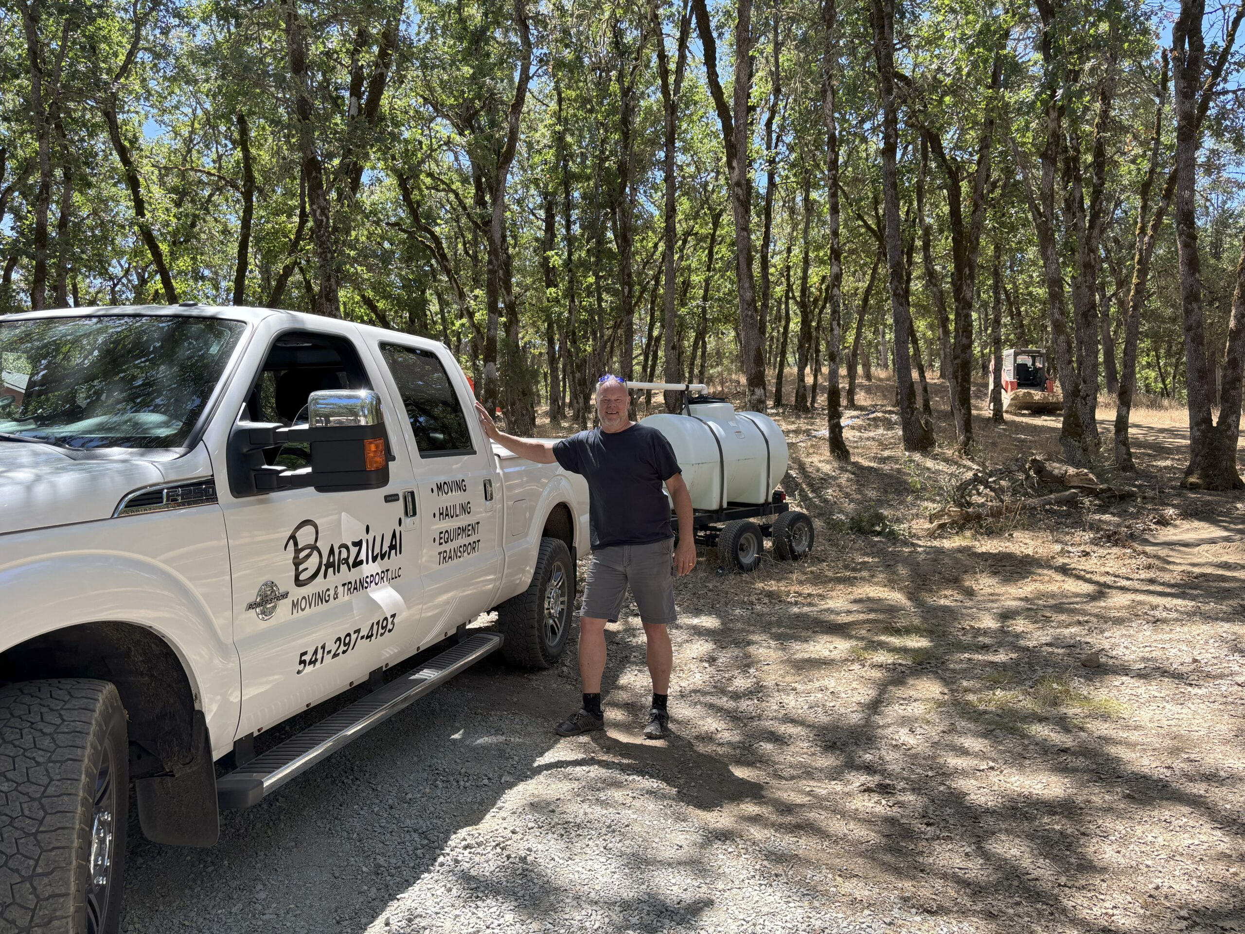 Barzillai truck and trailer during a recent equipment transport project in Southern Oregon, ensuring secure delivery of specialized loads.